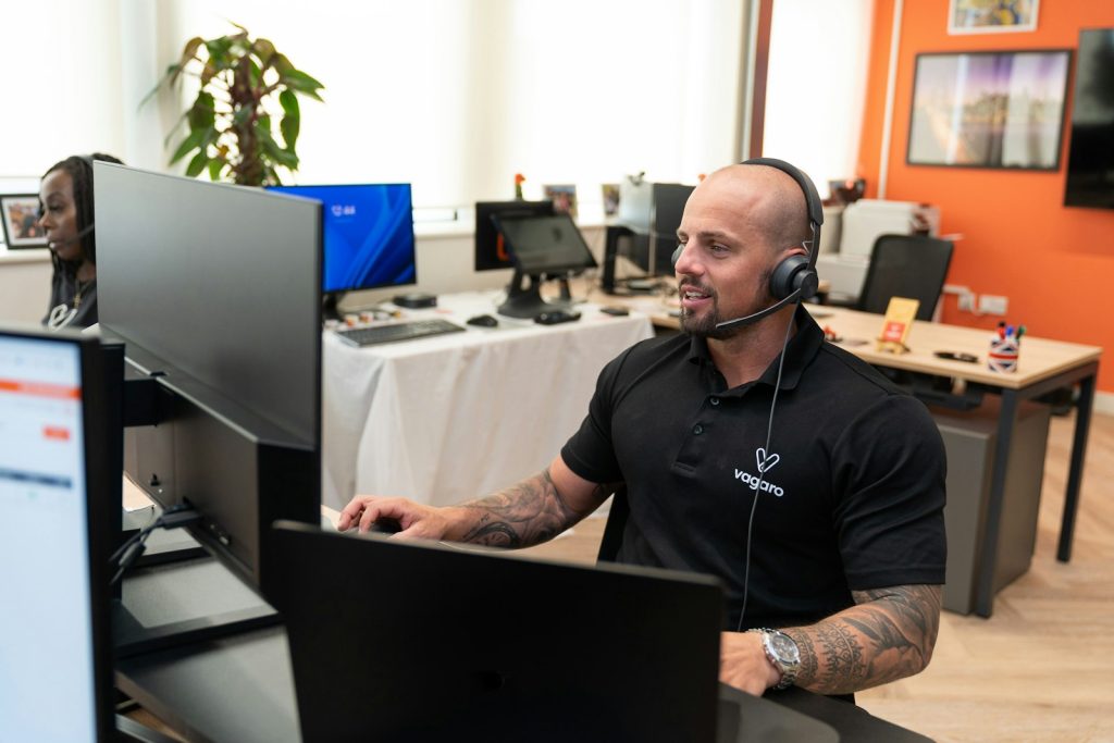 a man wearing a headset sitting in front of a computer